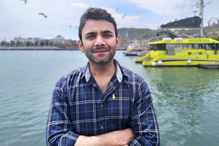 Portrait picture of Kashif Raza in front of a harbour